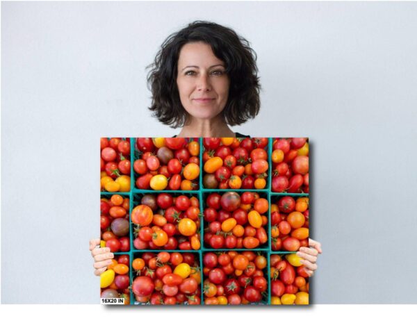 A woman holding up a box of tomatoes.