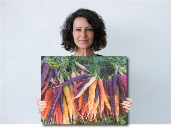 A woman holding up a picture of carrots.